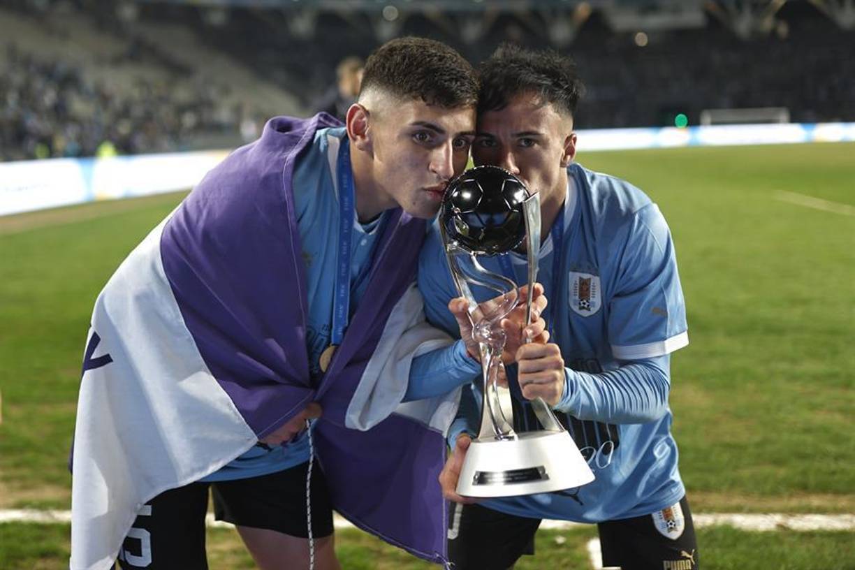 Fabricio Díaz (I) y Franco González (D) de Uruguay celebran con el trofeo de campeones de la justa mundialista.
