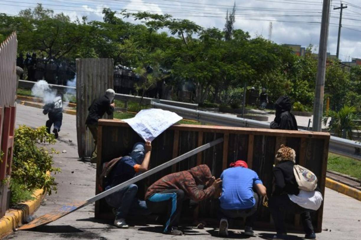 Los estudiantes encapuchados del Movimiento Estudiantil Universitario (MEU) se enfrentaron con la policía en el bulevar Suyapa de Tegucigalpa. AFP