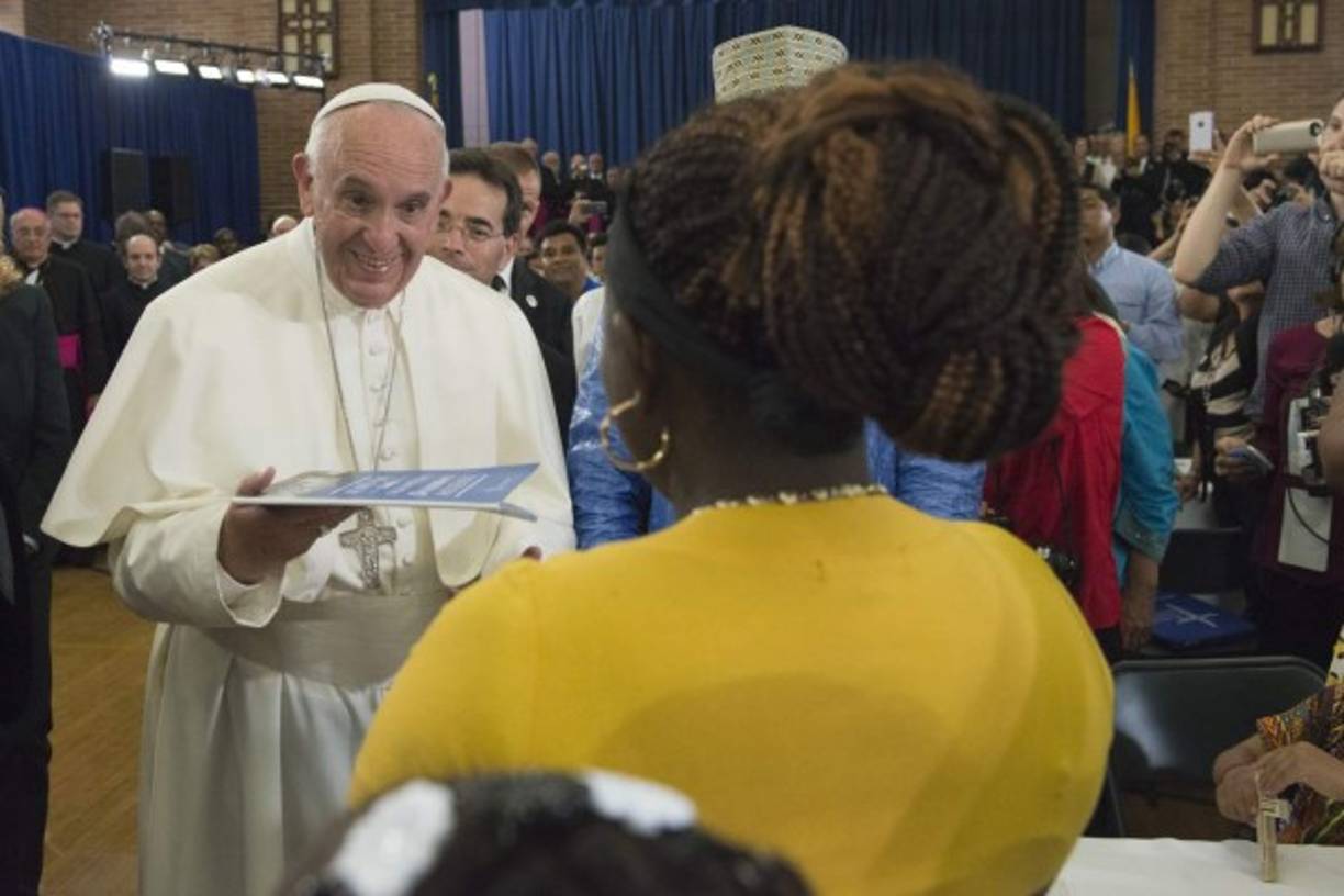 El papa Francisco recibe un regalo de una garífuna hondureña en la escuela Reina de Los Ángeles en la comunidad de Harlem en Nueva York, Estados Unidos.