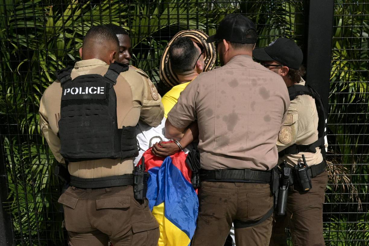 Personal de seguridad detienen a aficionados previo al ingreso al estadio.