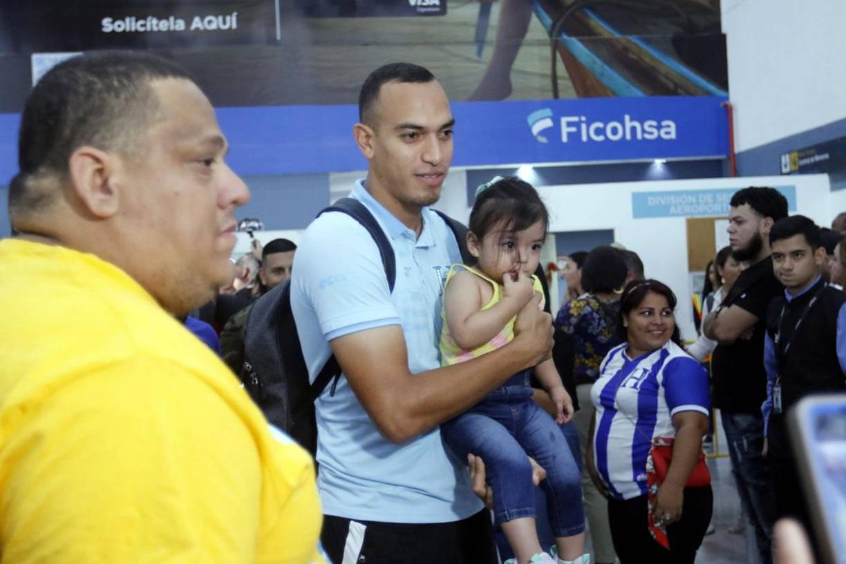El defensa hondureño Devron García cargando a una niña para la foto.