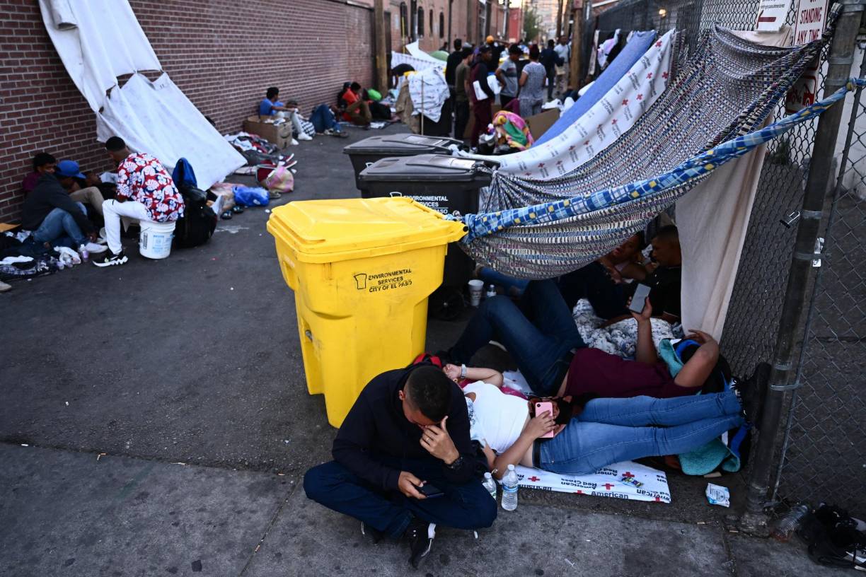 En El Paso, cientos de personas, incluidos niños, duermen en la calle, se protegen del sol con sábanas, duermen sobre cartones y algunos piden dinero.
