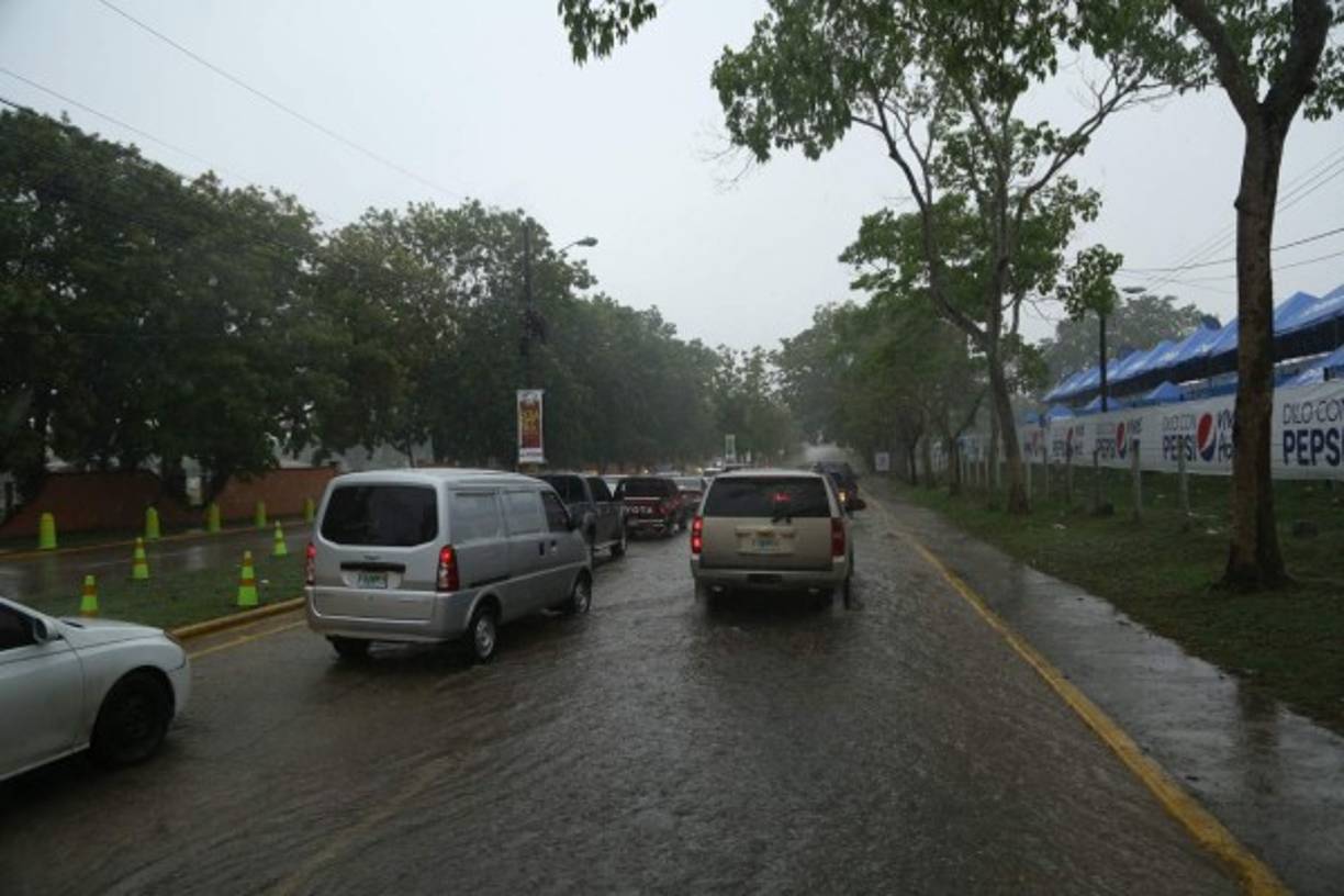 Las vehículos luchan por abrirse camino en medio de las inundadas calles.
