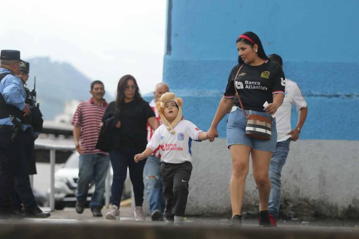 Una madre lleganco con su hijo con este peculiar gorrito de león al Estadio Nacional.