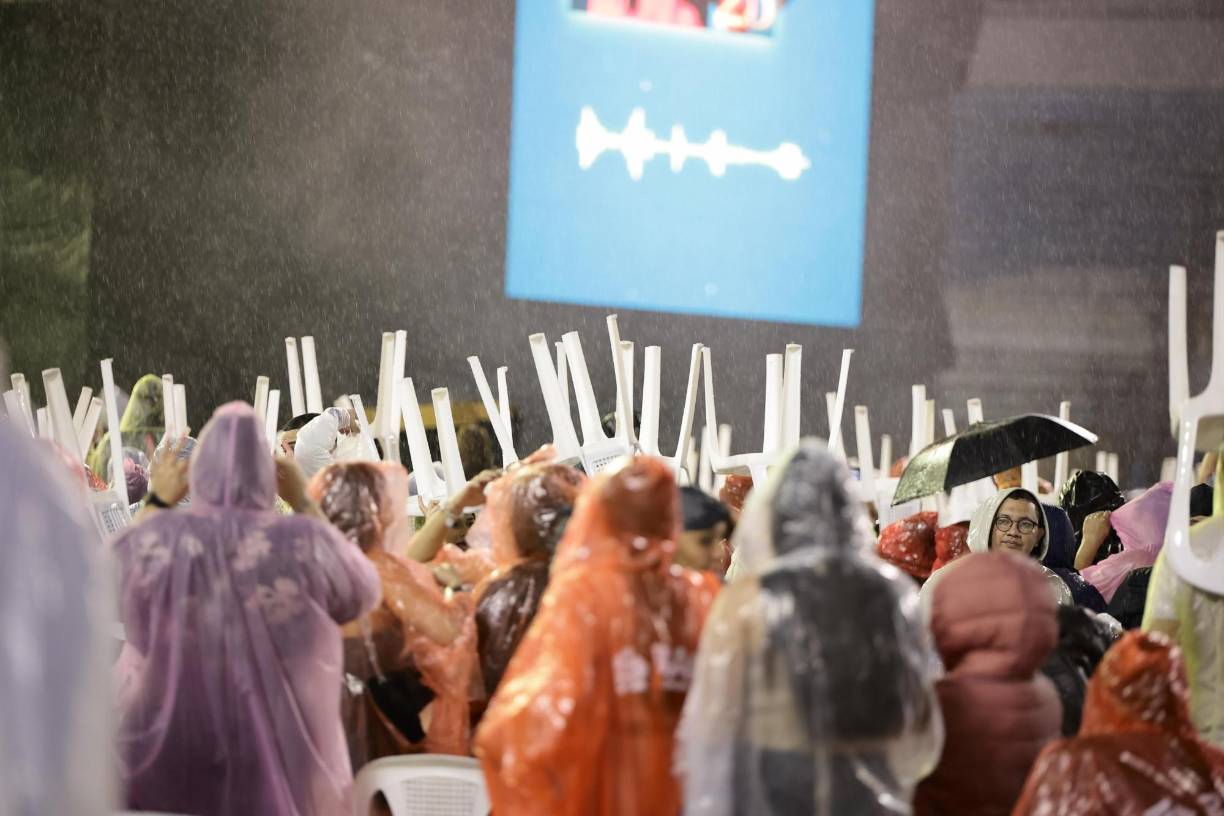 La mayoría de los que estaban en localidades sin techo tuvieron que utilizar las sillas para evitar mojarse la cabeza, ya que la lluvia comenzó a azotar muy fuerte. 