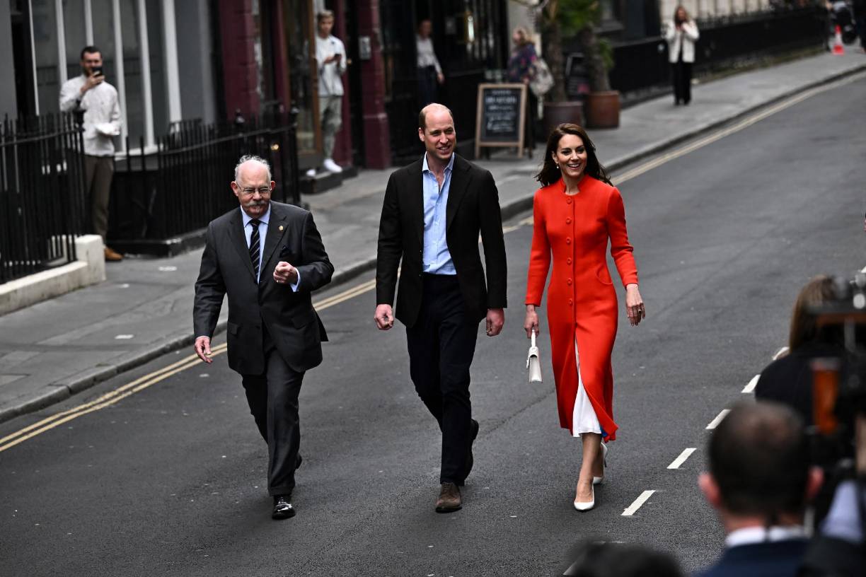 William, vestido con americana y sin corbata, y Catherine, con chaqueta roja y falda y zapatos blancos, se mostraron distendidos al saludar a los ciudadanos, en un acto incluido en los preparativos de la coronación el próximo sábado de Carlos III.