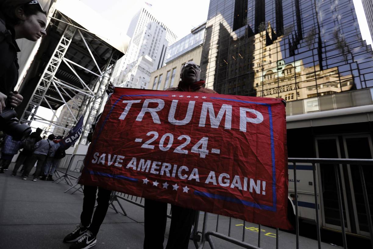 New York (United States), 03/04/2023.- A supporter of former US president Donald J. Trump stands near Trump Tower with a banner in New York, New York, USA, 03 April 2023. After being indicted by a Manhattan grand jury last week, Trump is traveling to New York and will reportedly turn himself in at New York Criminal Court on 04 April 2023 to hear the charges against him. (Estados Unidos, Nueva York) EFE/EPA/Peter Foley