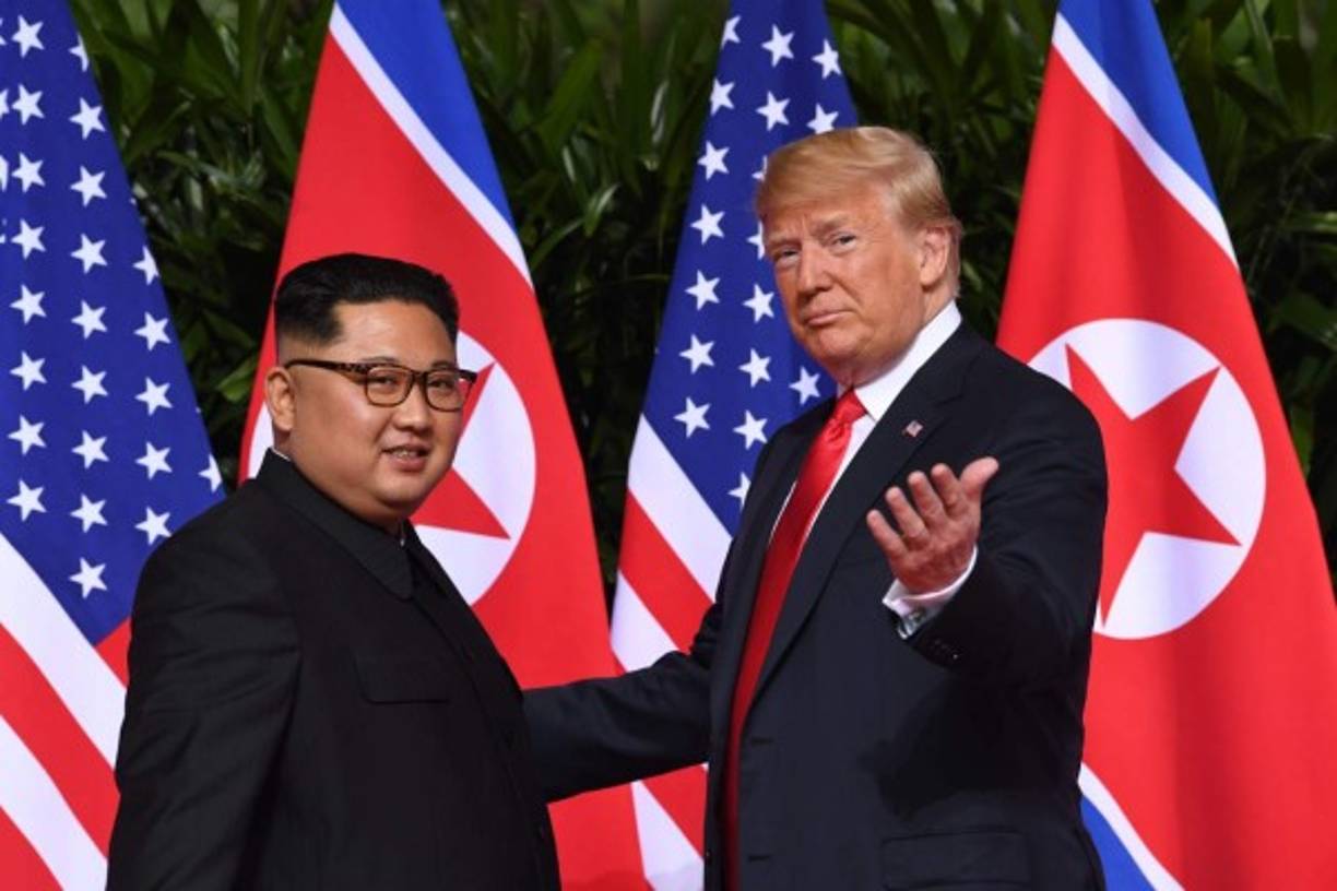 US President Donald Trump (R) gestures as he meets with North Korea's leader Kim Jong Un (L) at the start of their historic US-North Korea summit, at the Capella Hotel on Sentosa island in Singapore on June 12, 2018.<br/>Donald Trump and Kim Jong Un have become on June 12 the first sitting US and North Korean leaders to meet, shake hands and negotiate to end a decades-old nuclear stand-off. / AFP PHOTO / SAUL LOEB