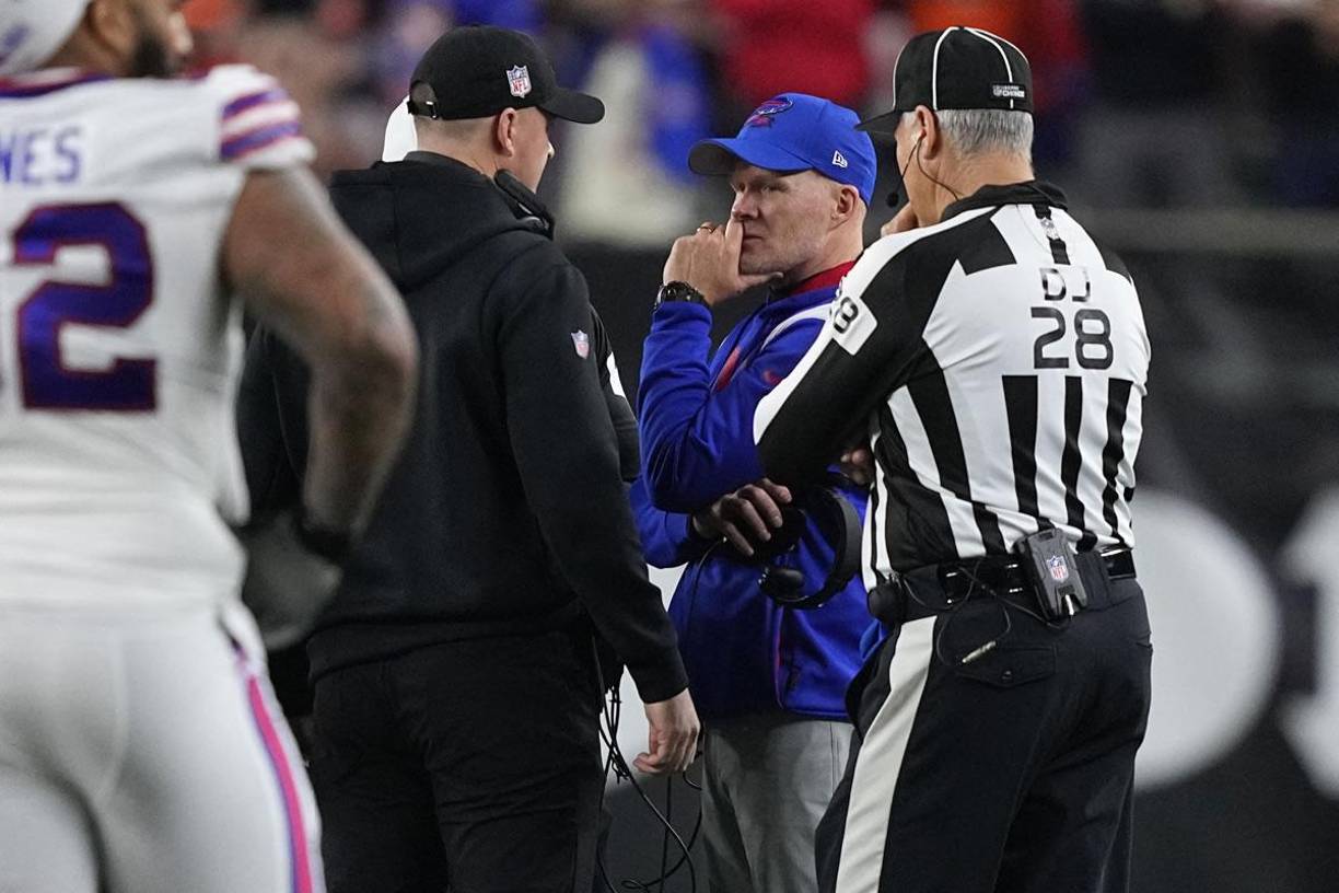 El entrenador en jefe Sean McDermott de los Buffalo Bills y Zac Taylor de los Cincinnati Bengals hablan durante la suspensión de su juego luego de la lesión de Damar Hamlin.
