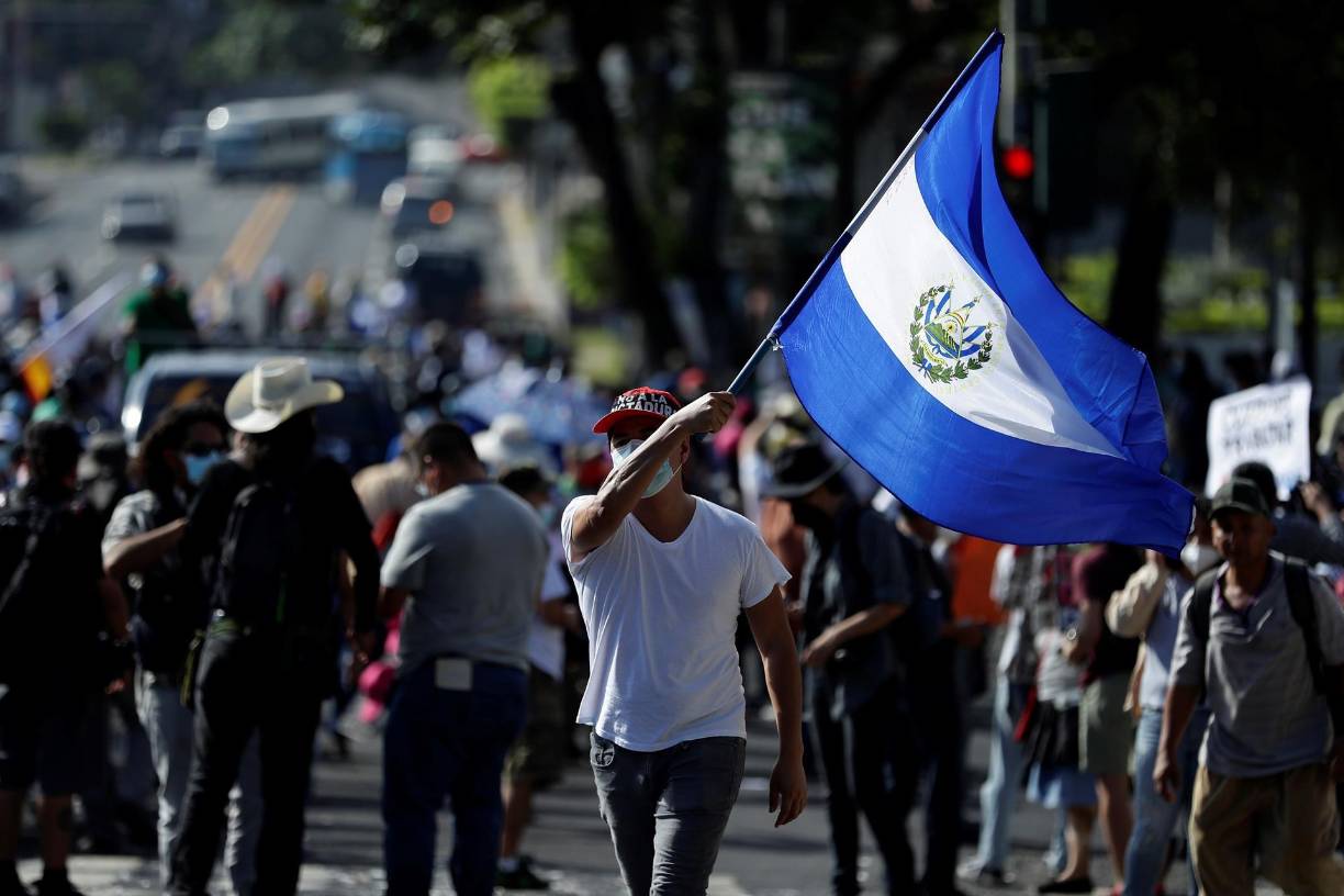 Un salvadoreño agita una bandera nacional en protesta contra las decisiones “arbitrarias” del Gobierno del presidente Bukele. 