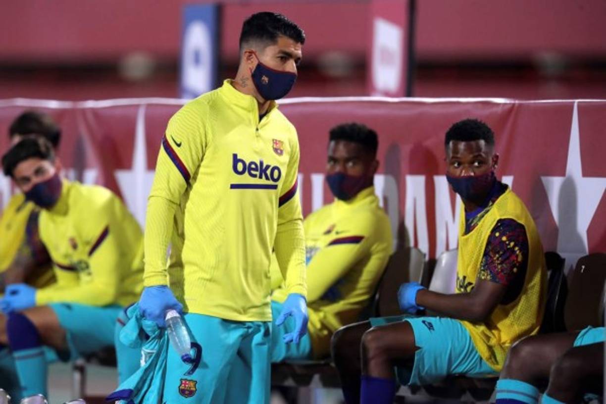 Luis Suárez y sius compañeros suplentes, en el banquillo con mascarillas y guantes siguiendo con las medidas de bioseguridad.