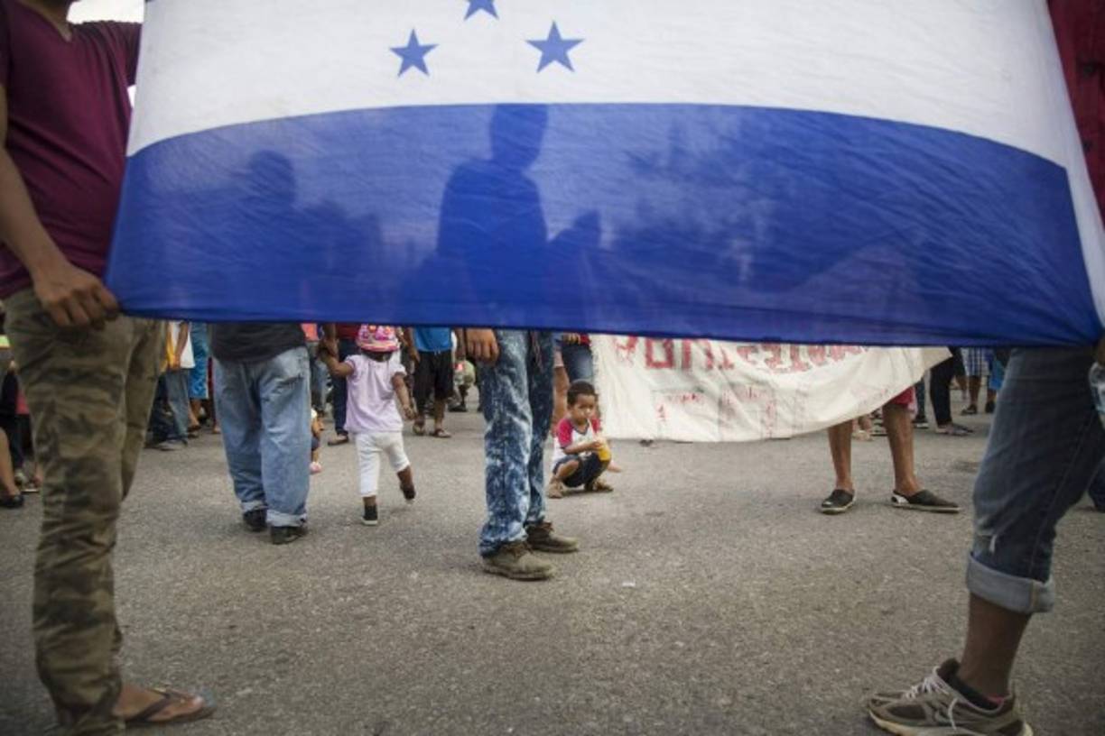 Los hondureños muestran su bandera en la caravana del Migrante.