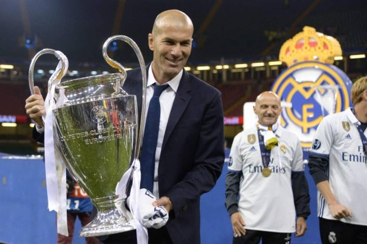 Real Madrid's French coach Zinedine Zidane lifts the trophy after Real Madrid won the UEFA Champions League final football match between Juventus and Real Madrid at The Principality Stadium in Cardiff, south Wales, on June 3, 2017. / AFP PHOTO / Filippo MONTEFORTE
