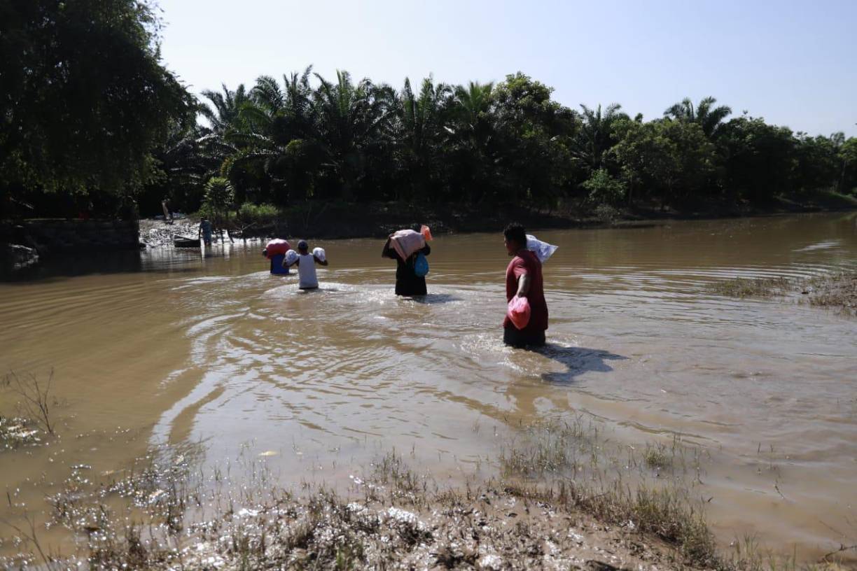 Pobladores ayudan a trasladar los víveres durante la operación de envío en los bajos cholomeños.