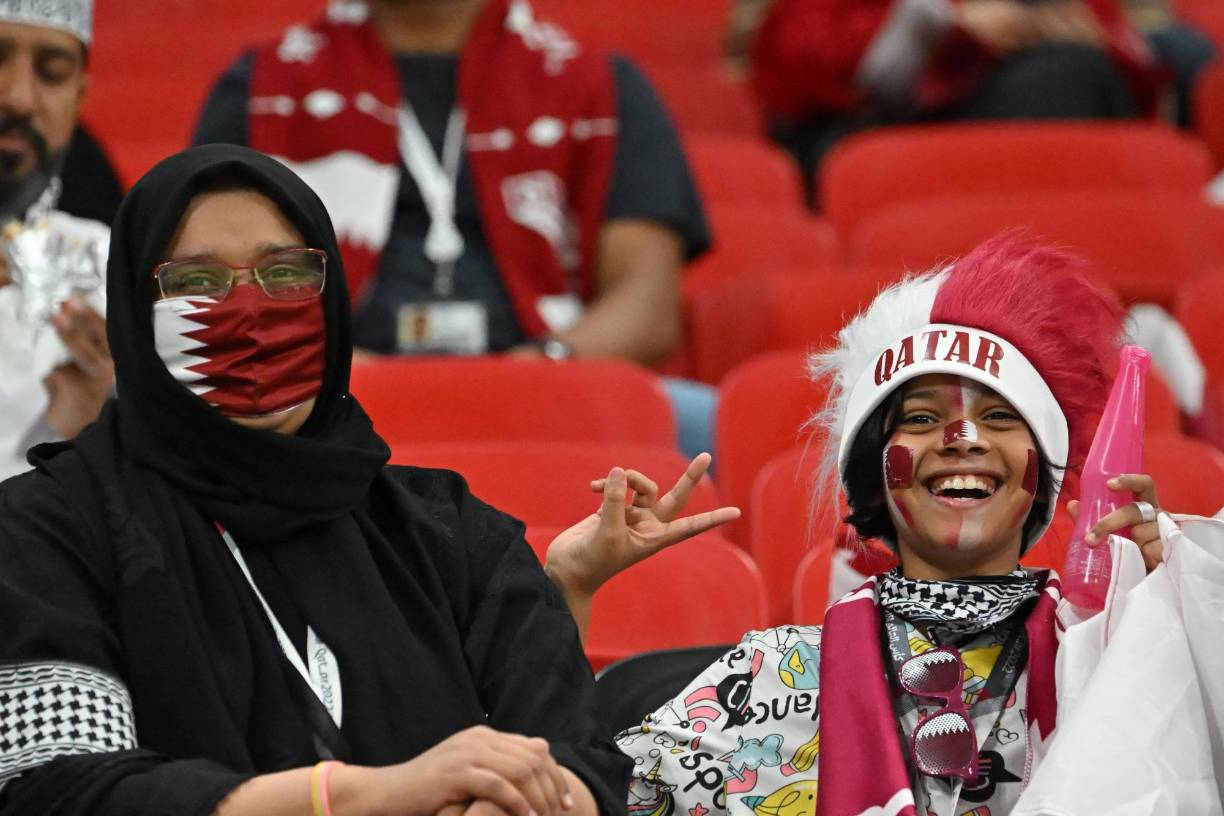 Aficionada qatarí junto a un pequeño fanatico en el Estadio Al Bayt.