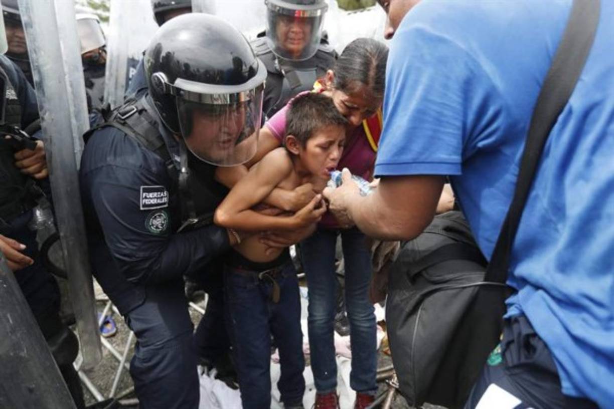Una madre y su hijo reciben atención luego de quedar atrapados en el tumulto de migrantes que trataba de entrar a México.