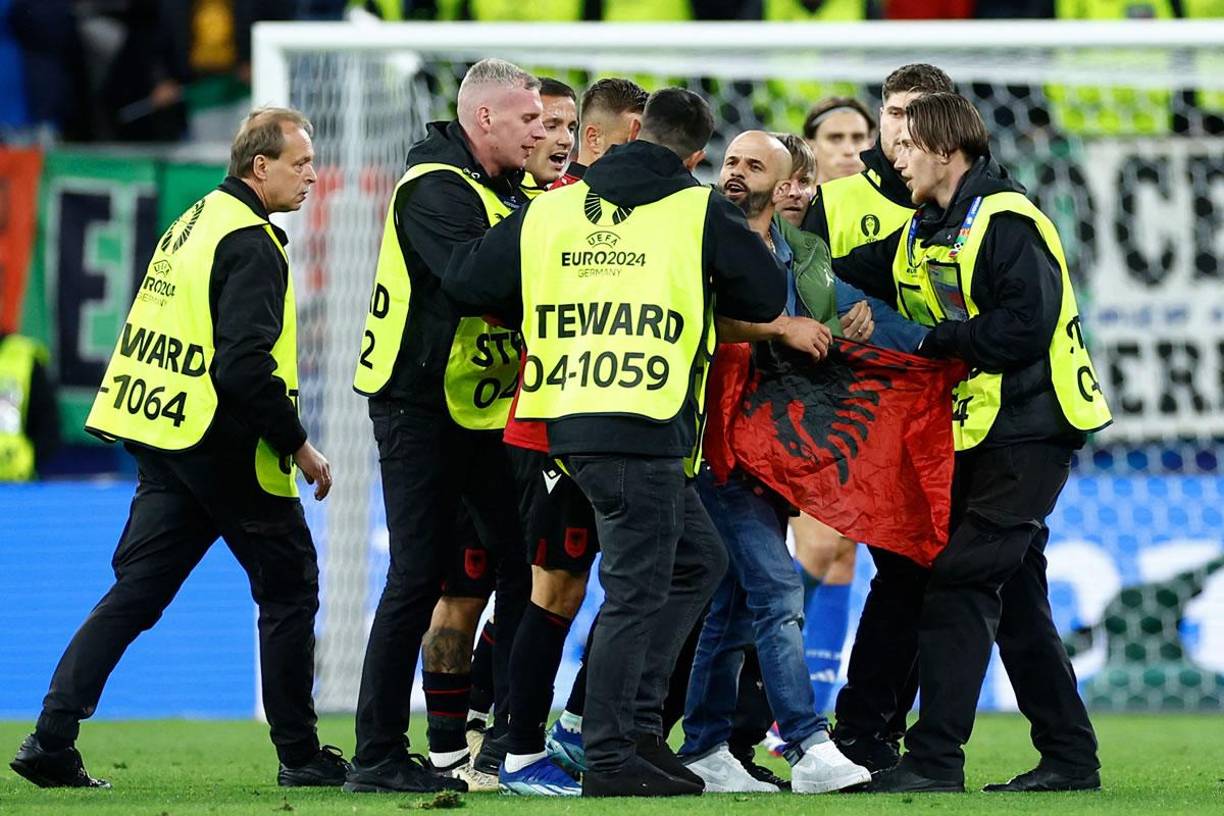 Miembros de seguridad detuvieron al aficionado de Albania que invadió el campo con una bandera de su país.