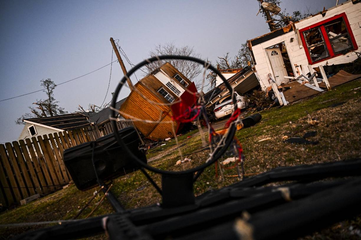 Filas enteras de casas han sido arrancadas de sus escasos cimientos, las calles están llenas de escombros y se ven algunos automóviles en los techos de las viviendas, así como árboles derribados y con trozos de metal enroscados en sus troncos.