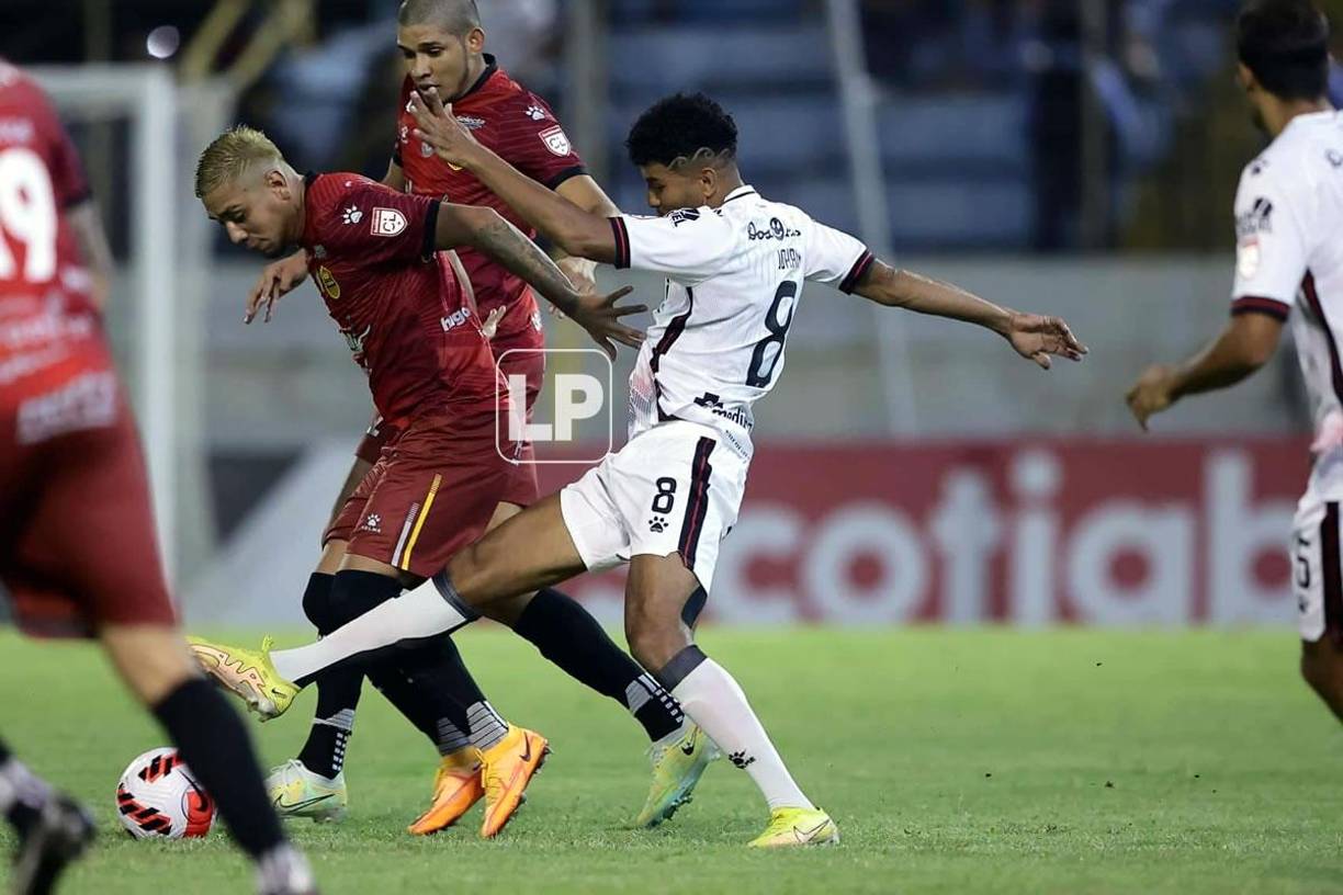 El jugador tico Johan Venegas marcando al mediocampista del Real España, Mayron Flores.