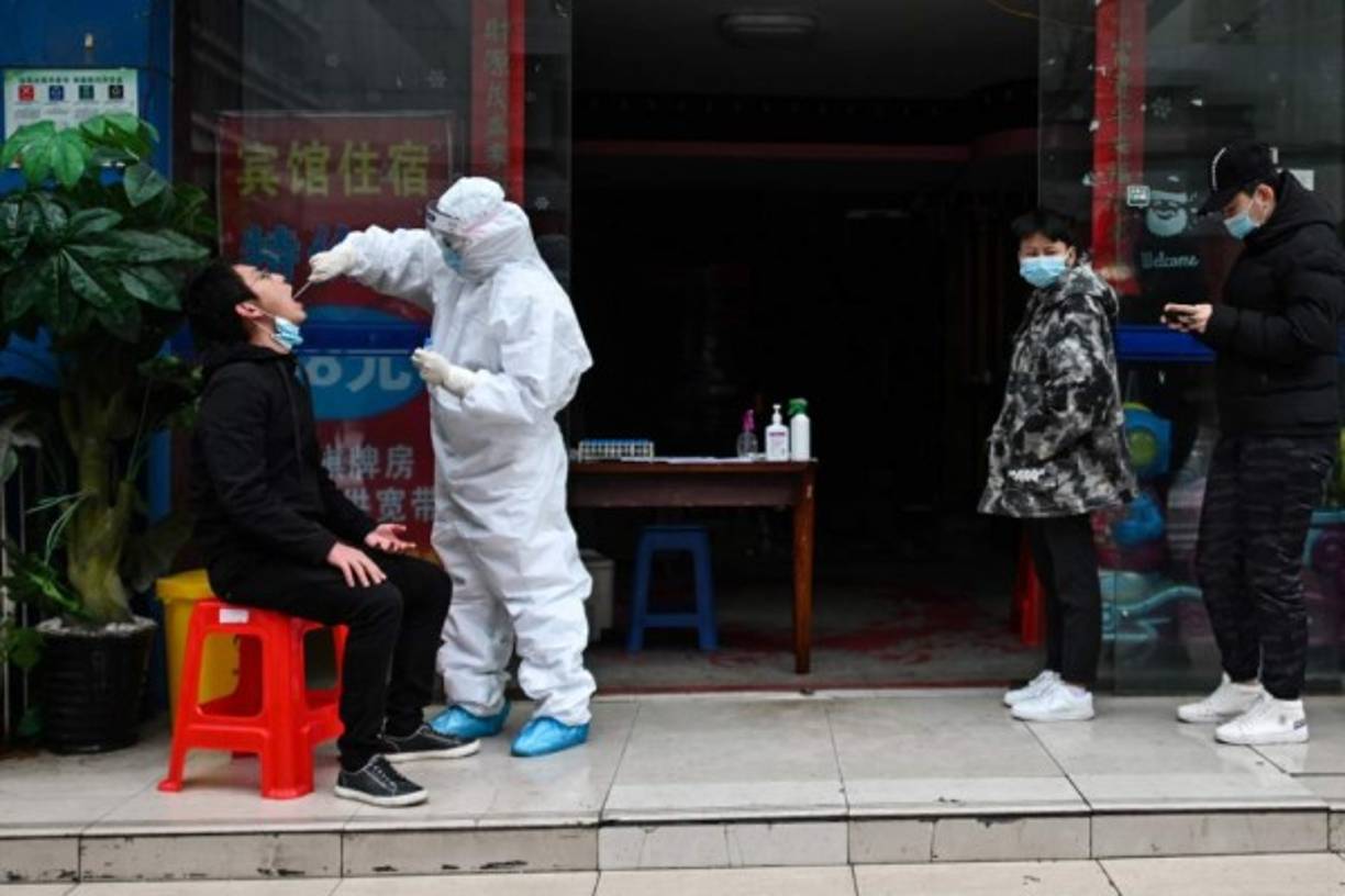A man wearing a face mask sells duck in his shop in Wuhan, China's central Hubei province on April 14, 2020. - China has largely brought the coronavirus under control within its borders since the outbreak first emerged in the city of Wuhan late last year. (Photo by Hector RETAMAL / AFP)