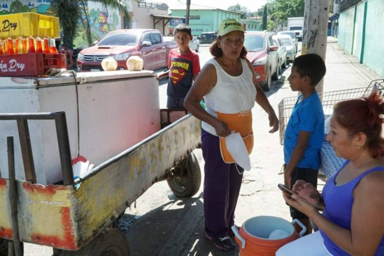 Esta señora trabaja en la calle vendiendo cocos y frescos para poder ganarse la vida.