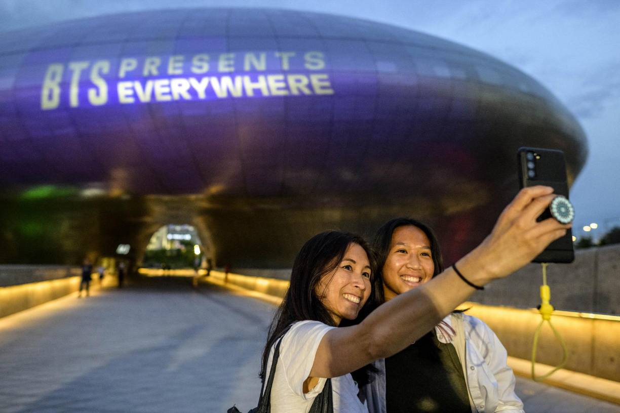 Una madre y su hija se toman una selfie frente a Dongdaemun Design Plaza.
