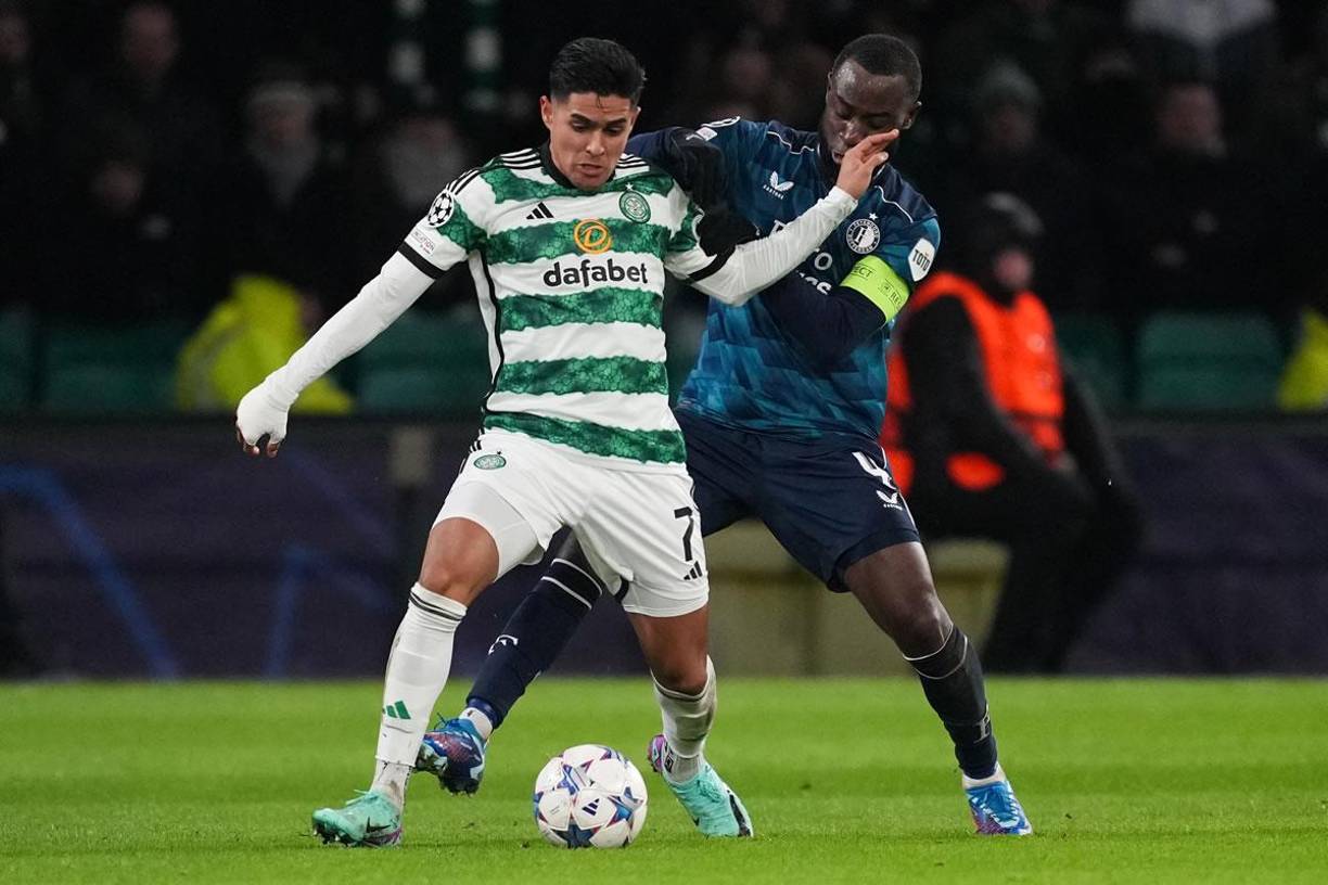 Luis Palma cubriendo el balón ante la marca del defensa y capitán del Feyenoord, el neerlandés Lutsharel Geertruida.