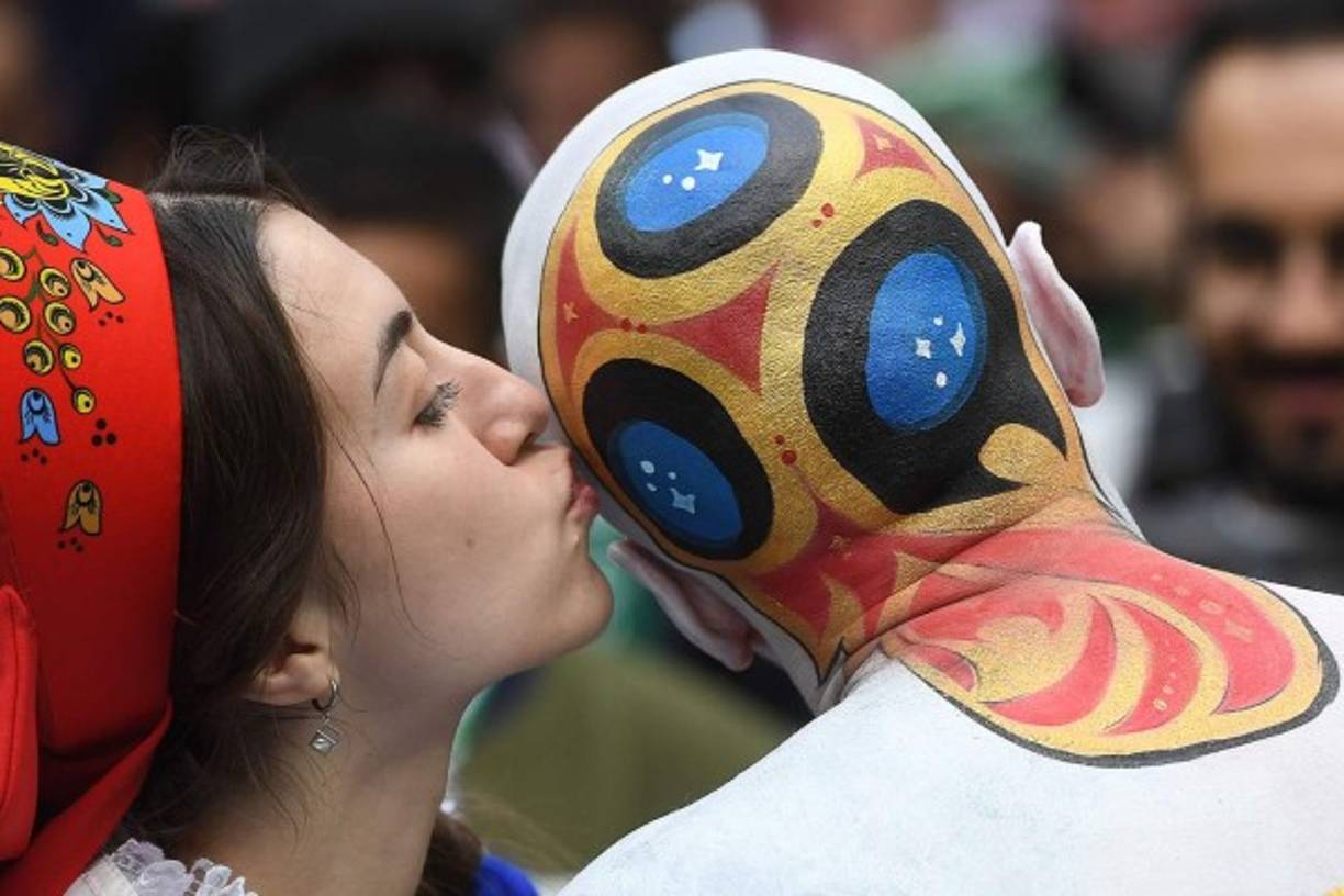 Una fanática besa la cabeza de un hombre que se mandó a hacer la figura de la copa.