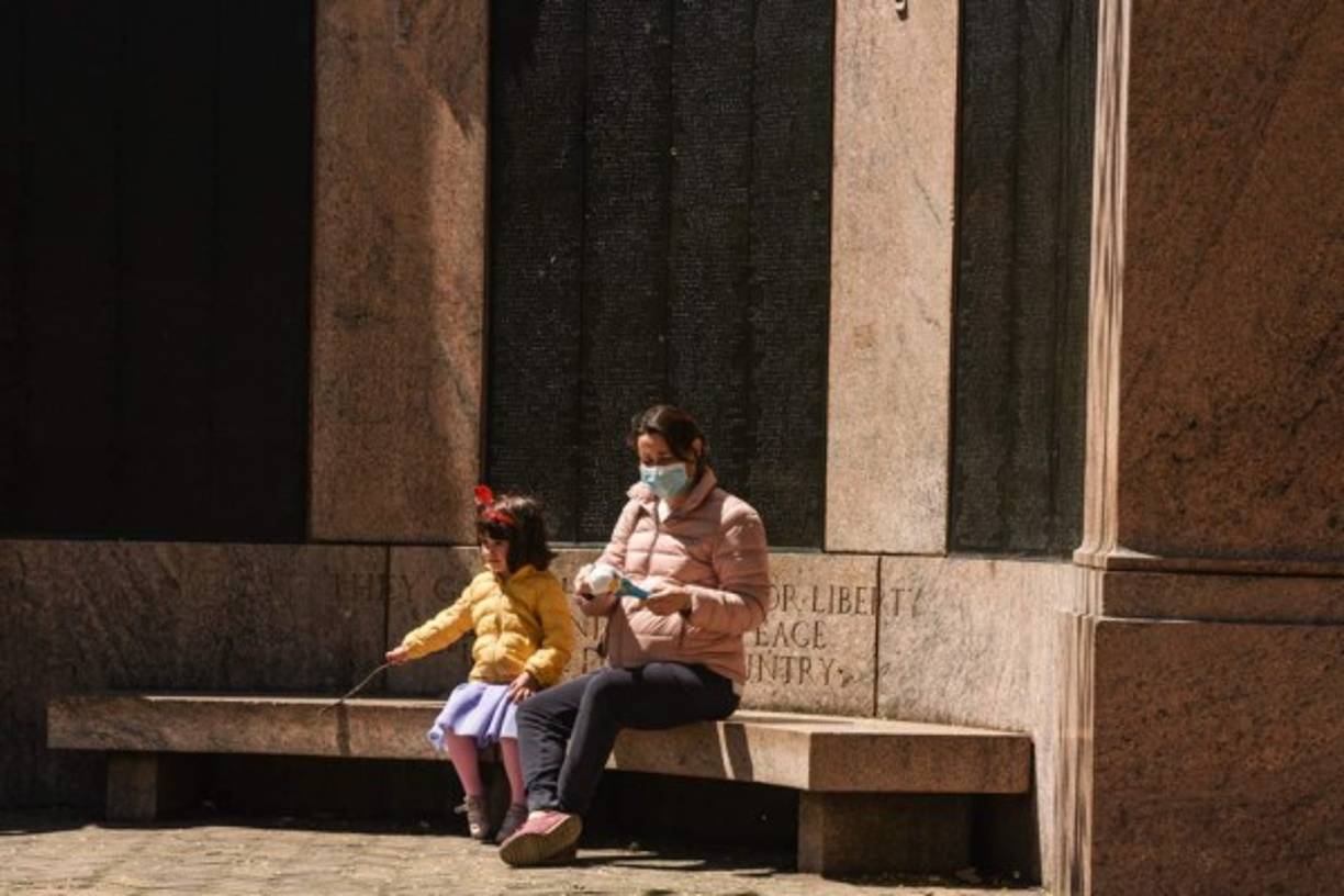 Una madre y un niño se sientan hoy en un banco en Prospect Park en el distrito de Brooklyn en la ciudad de Nueva York.<br/>