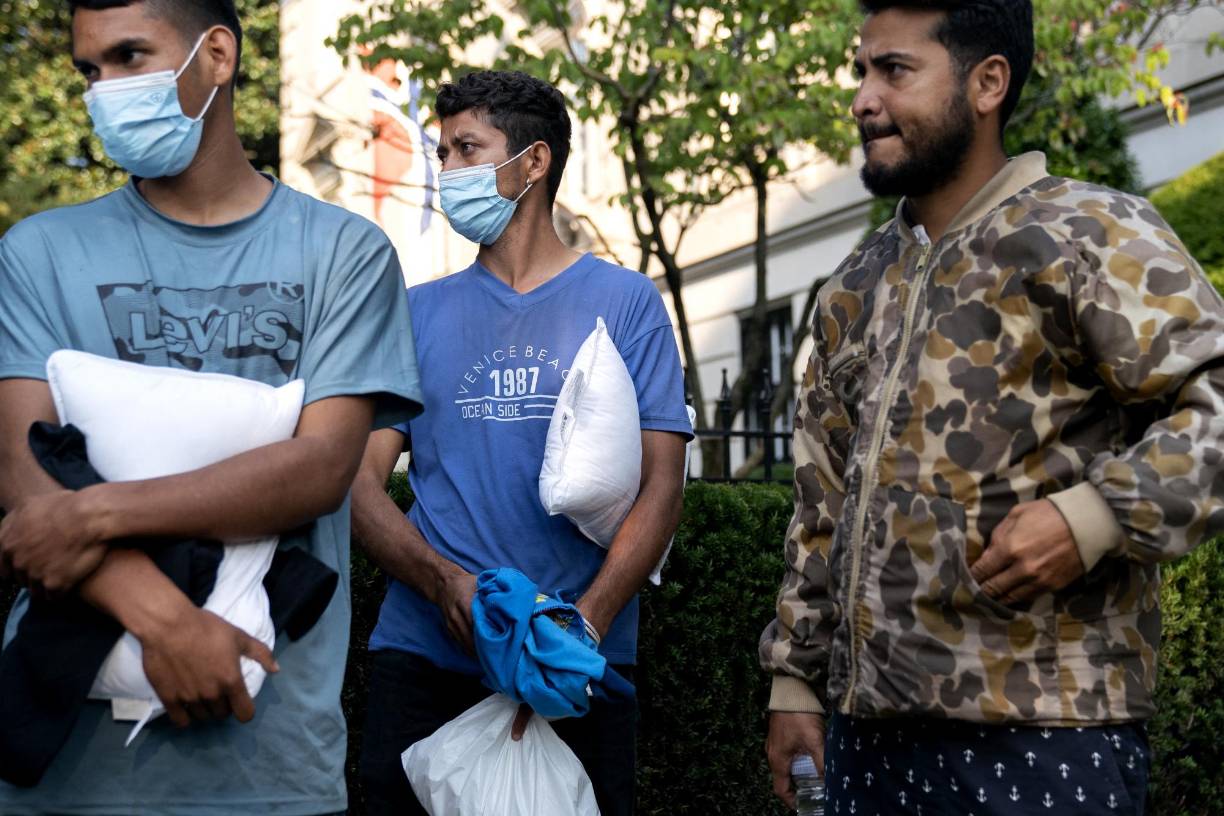 Migrants from Venezuela, who boarded a bus in Texas, stand outside the residence of US Vice President Kamala Harris, at the Naval Observatory in Washington, DC, on September 15, 2022. - Since April, Texas Governor Greg Abbott has ordered buses to carry thousands of migrants from Texas to Washington, DC, New York City, and Chicago to highlight criticisms of US President Joe Biden’s border policy. (Photo by Stefani Reynolds / AFP)