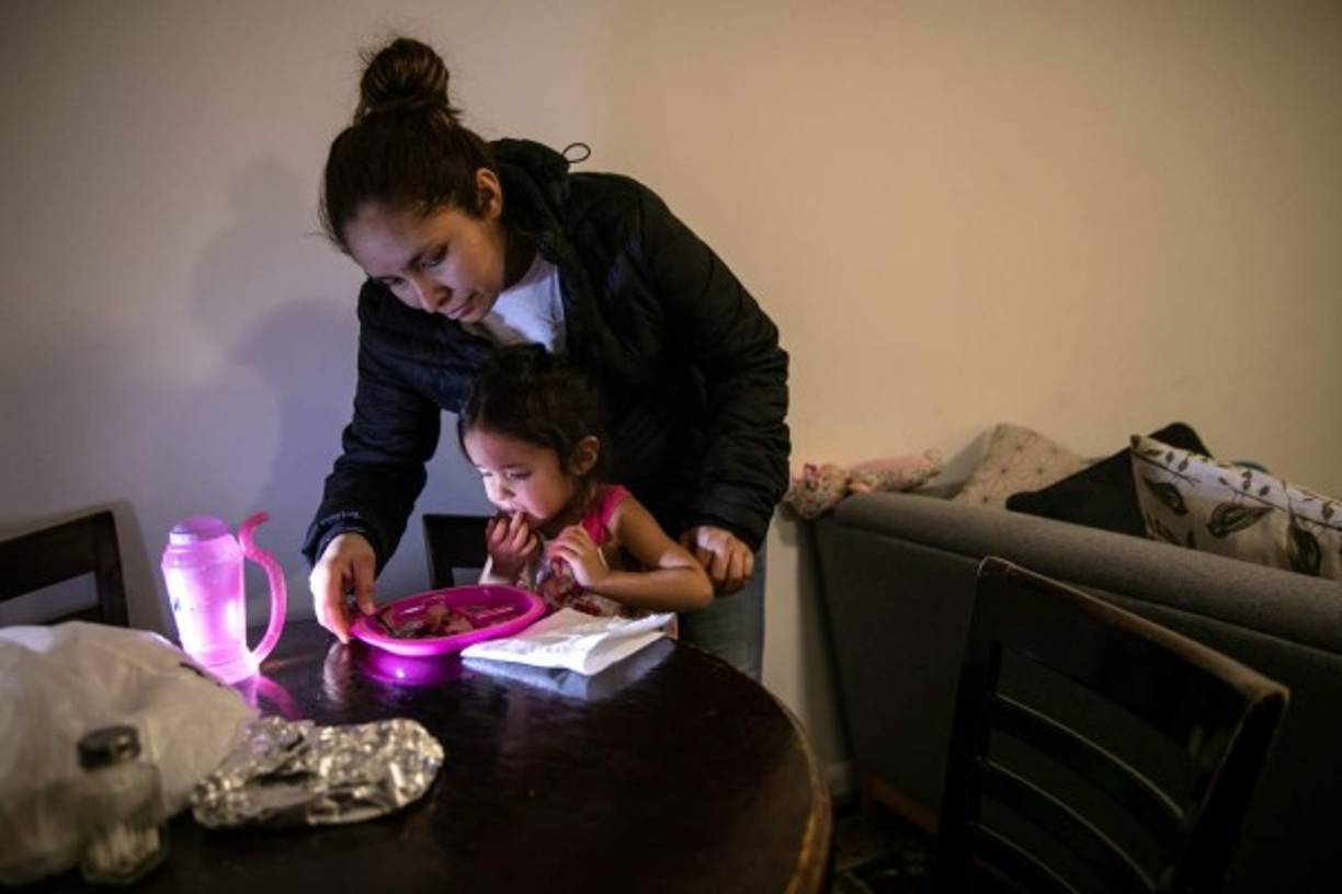 La solicitante de asilo Yanela Sánchez con su hija en el apartamento donde reside mientras espera una respuesta de asilo. AFP