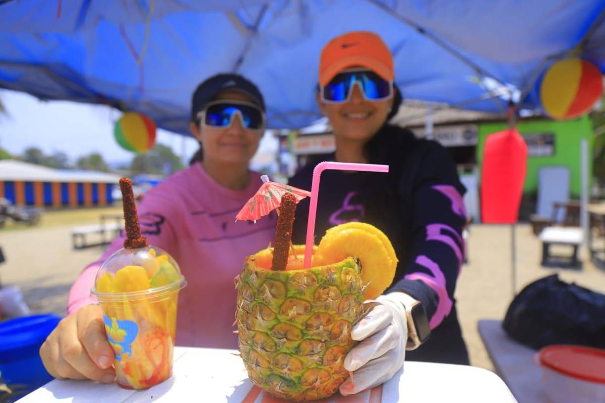 Los comerciantes también se las ingenian para atraer la clientela. Dos jóvenes muestran una piña colada y un mango loco.