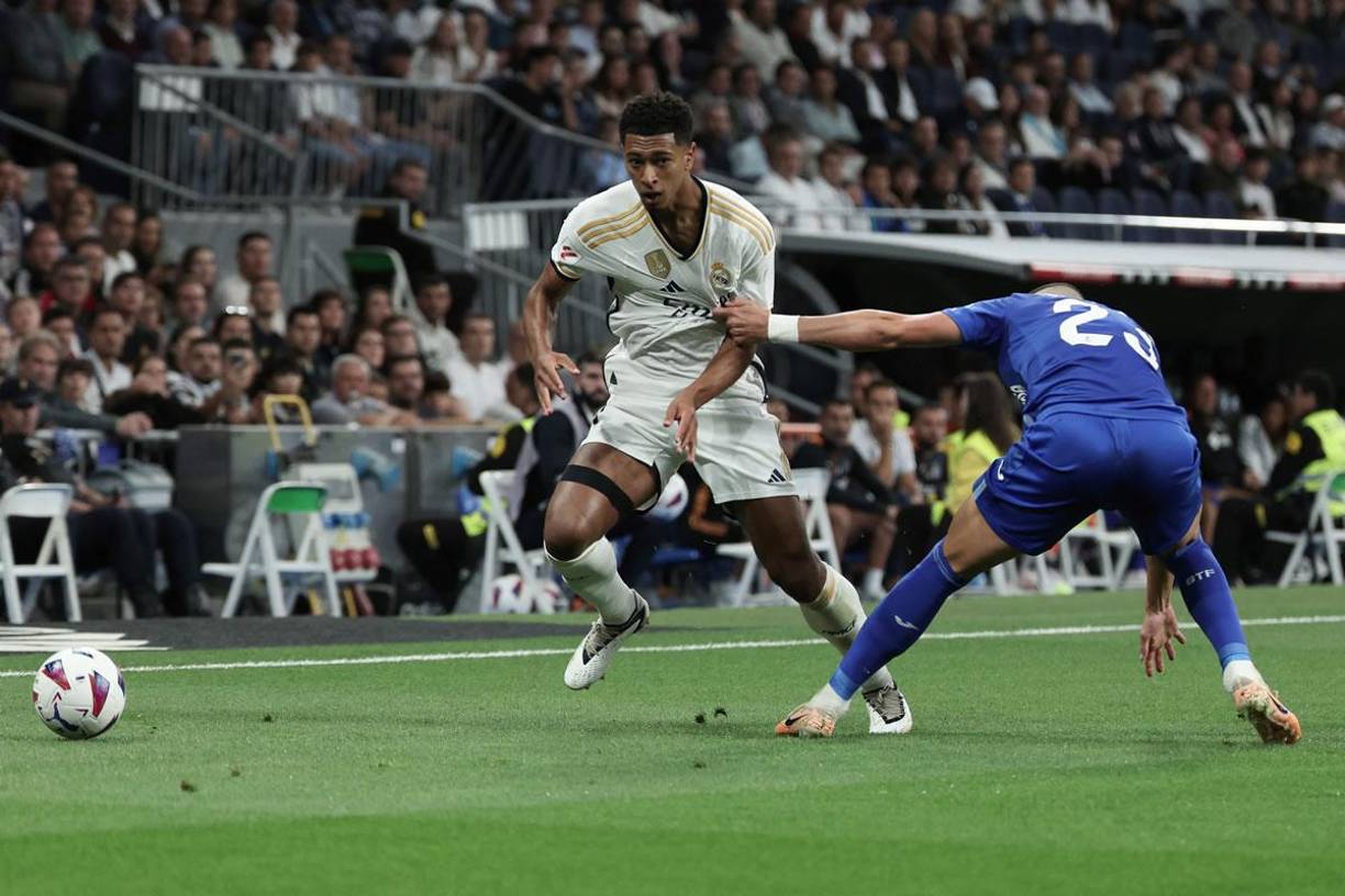 Jude Bellingham superando la marca del serbio Stefan Mitrović.