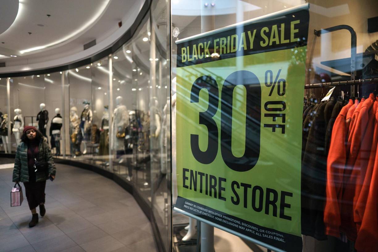 Un comprador pasa frente a un escaparate de una tienda dentro del Fashion Center en Pentagon City durante las compras del Viernes Negro en Arlington, Virginia. 