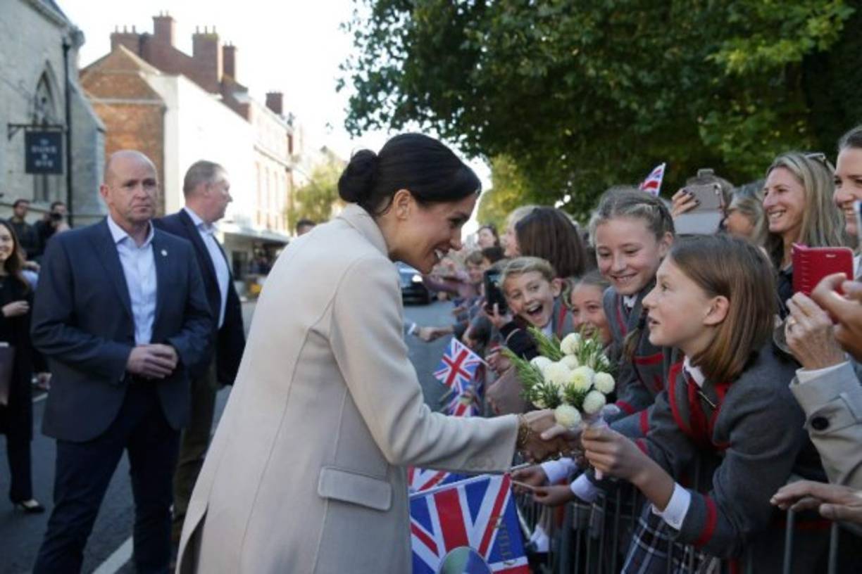 La pareja se bajó del coche oficial para saludar a las personas congregadas en las calles de la localidad, que da nombre el título nobiliario que la reina Isabel II otorgó al príncipe Harry tras su boda el pasado 19 de mayo en el castillo de Windsor.
