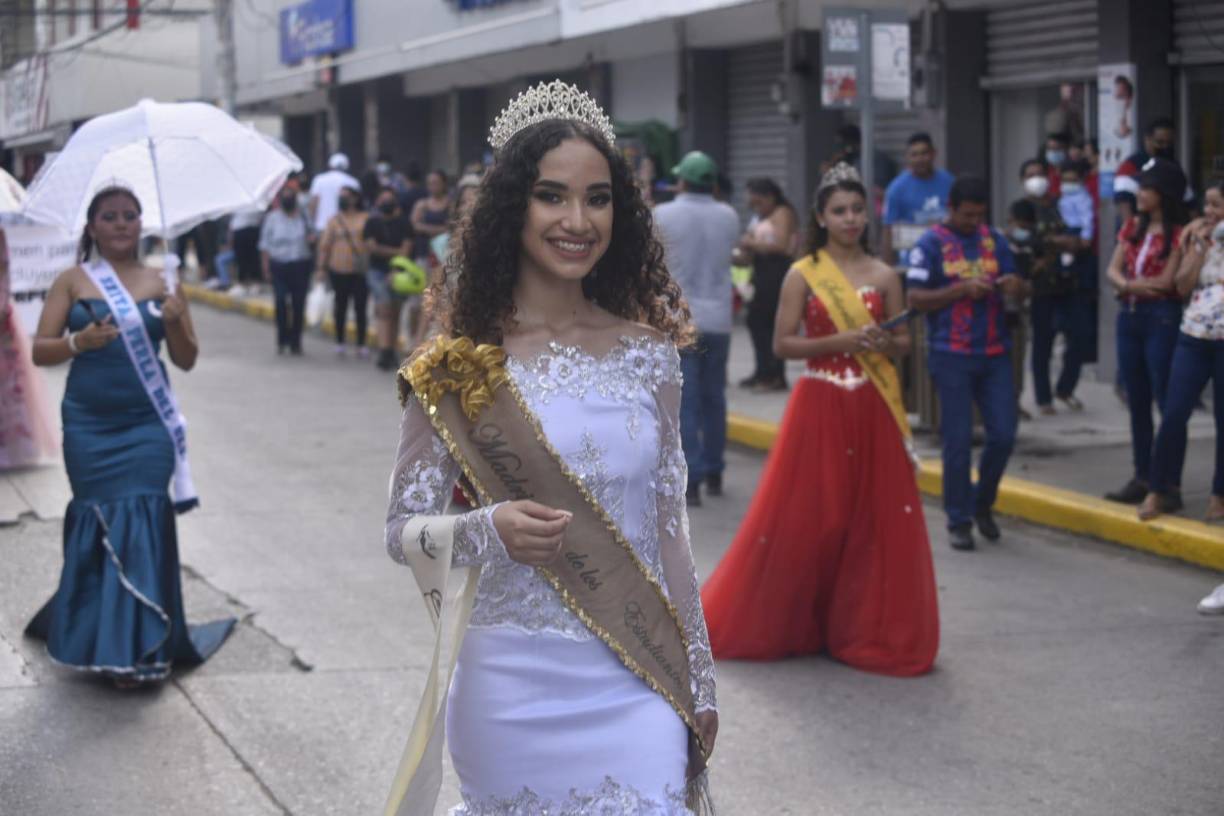 Esta bella reina luce su hermoso cabellos rizado y un vestido blanco.