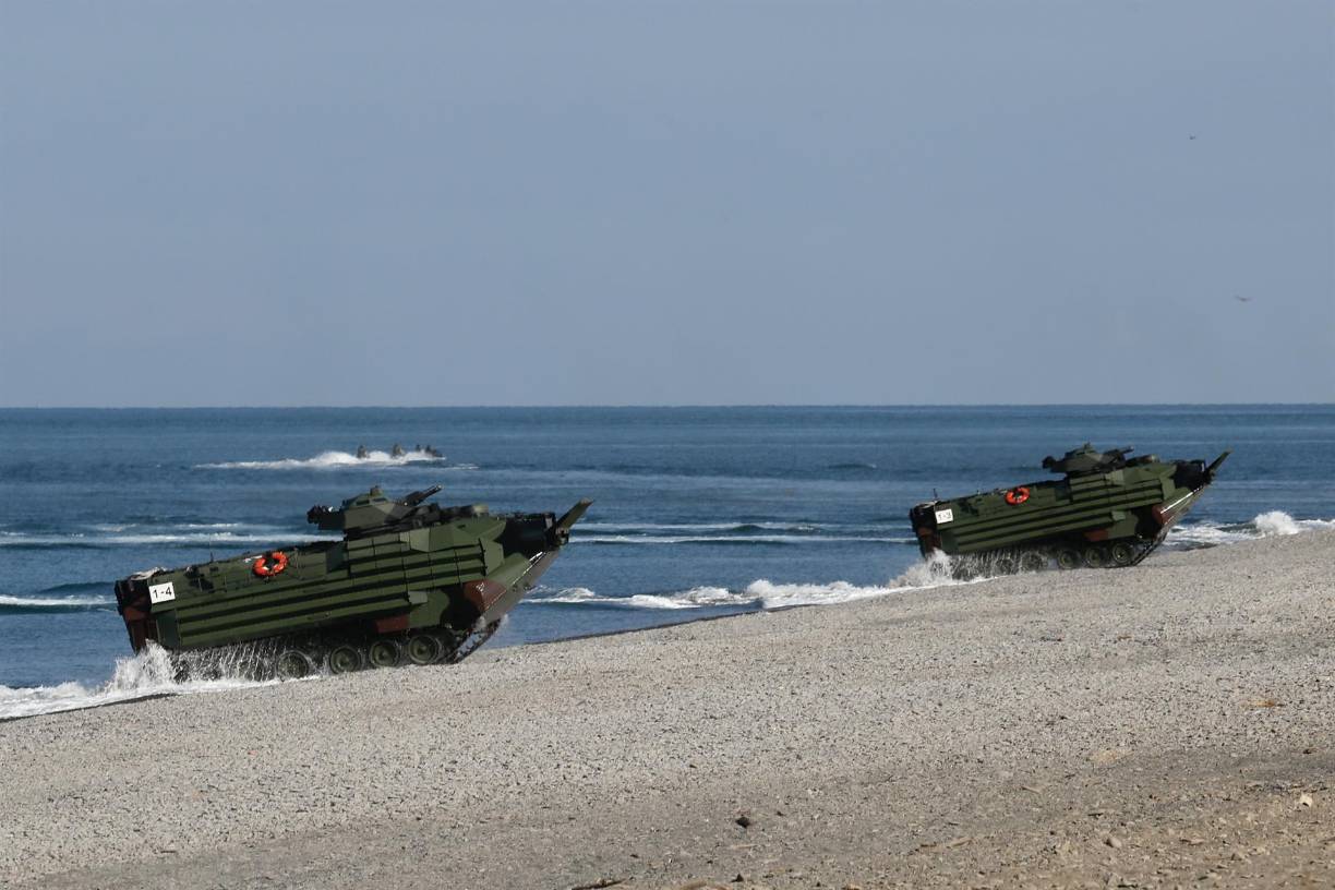 Durante un simulacro para rechazar el acceso del enemigo a la capital, Taipéi, los reservistas armados con ametralladoras atravesaron trincheras de arena excavadas debajo de un puente antes de pasar a la posición de fuego. 