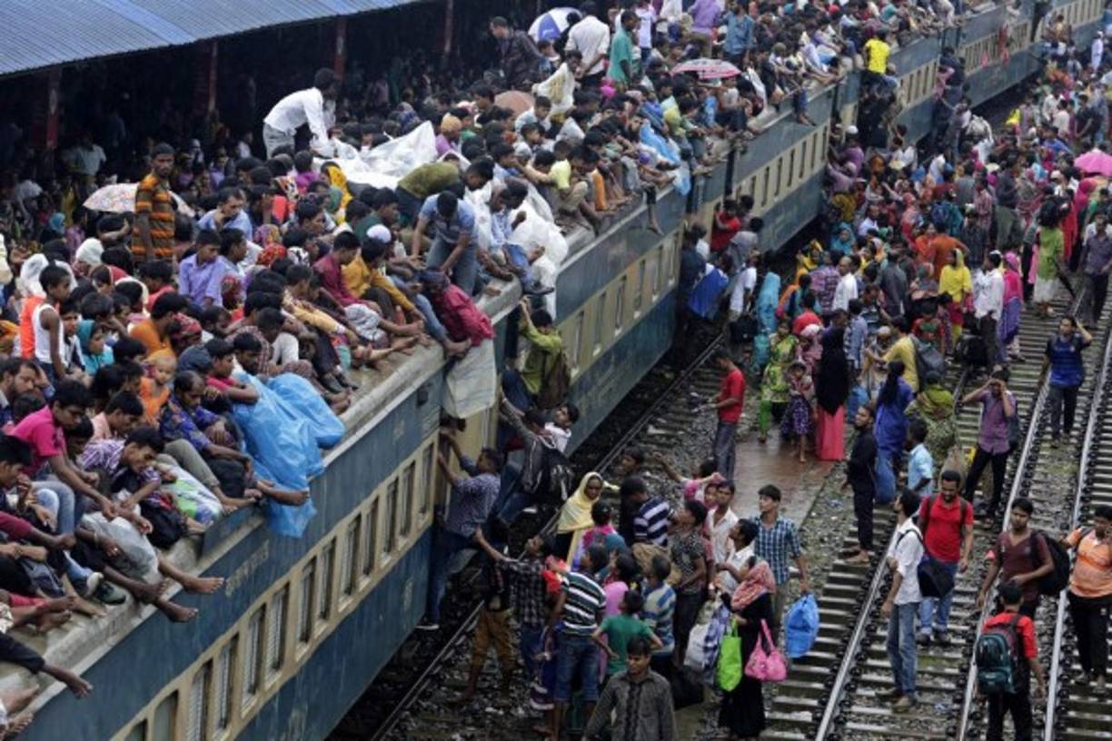 BANGLADESH. Viajan hasta en el techo. Cientos de personas intenta subir al techo de un tren en Dhaka, van a sus pueblos a celebrar fin de Ramadán.