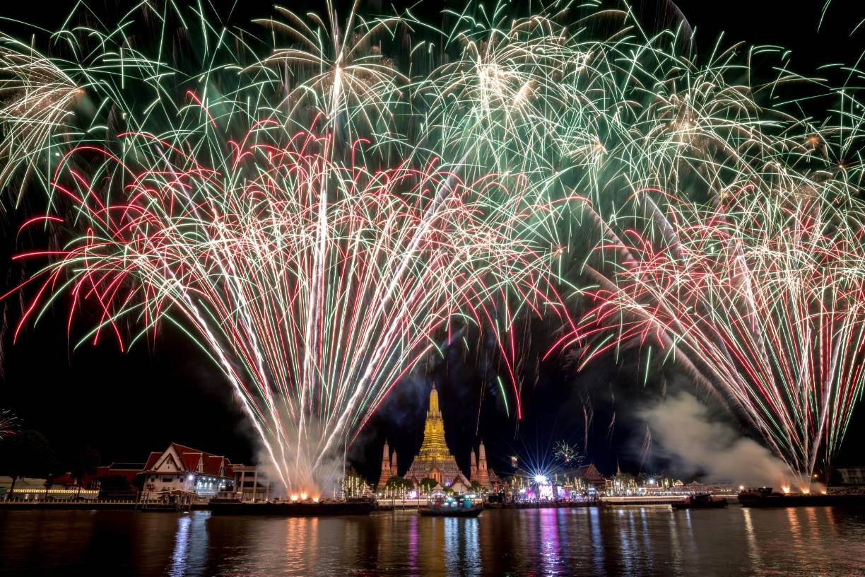 <b>Tailandia.</b> Esta fotografía tomada el 1 de enero de 2023 muestra un espectáculo de fuegos artificiales sobre el templo budista Wat Arun en el río Chao Phraya durante las celebraciones de Año Nuevo en Bangkok. 