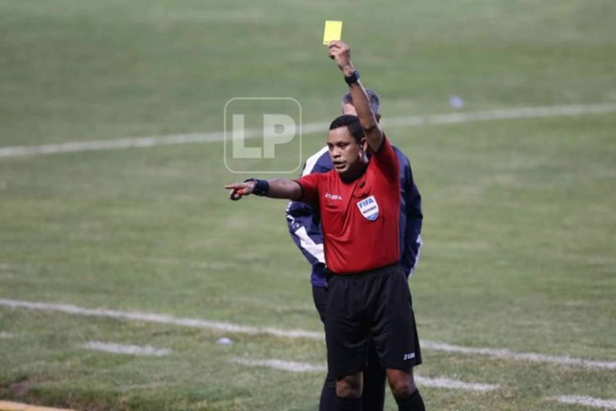 El árbitro Selvin Brown le muestra tarjeta amarilla a un integrante del Motagua en el banquillo.