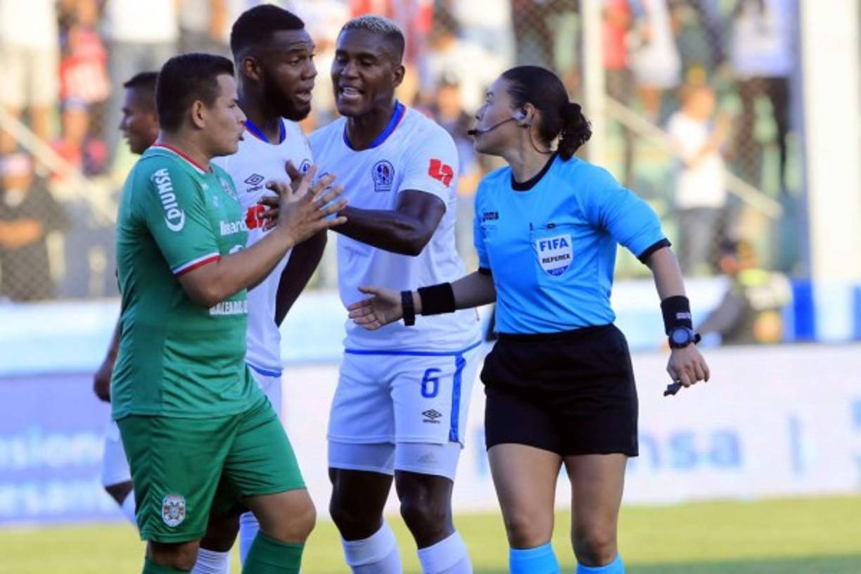 Kevin Espinoza, del Marathón, y Jorge Benguché, del Olimpia, le reclaman a la árbitro Melissa Pastrana, mientras Brayan Beckeles tratan de calmarlos.