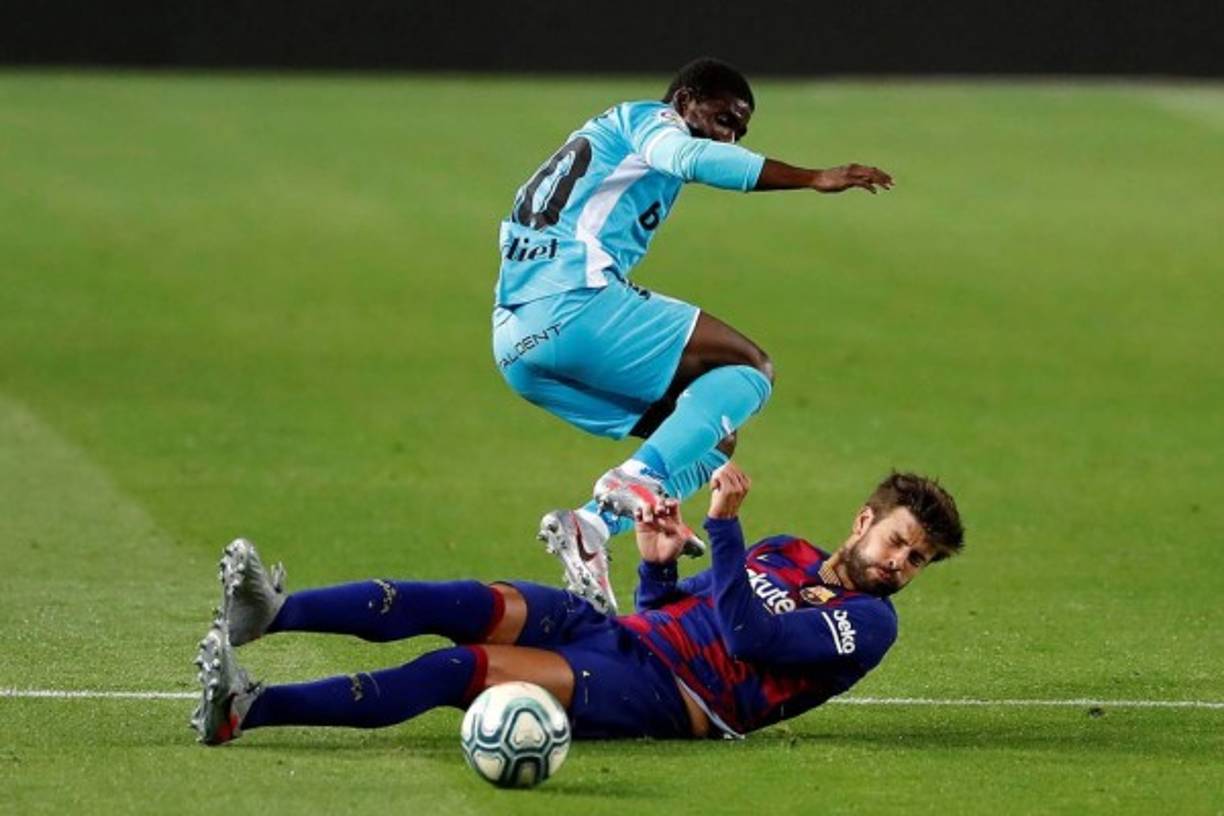 Gerard Piqué (suelo), corta el avance del delantero costa marfileño del CD Leganés, Roger Assalé.