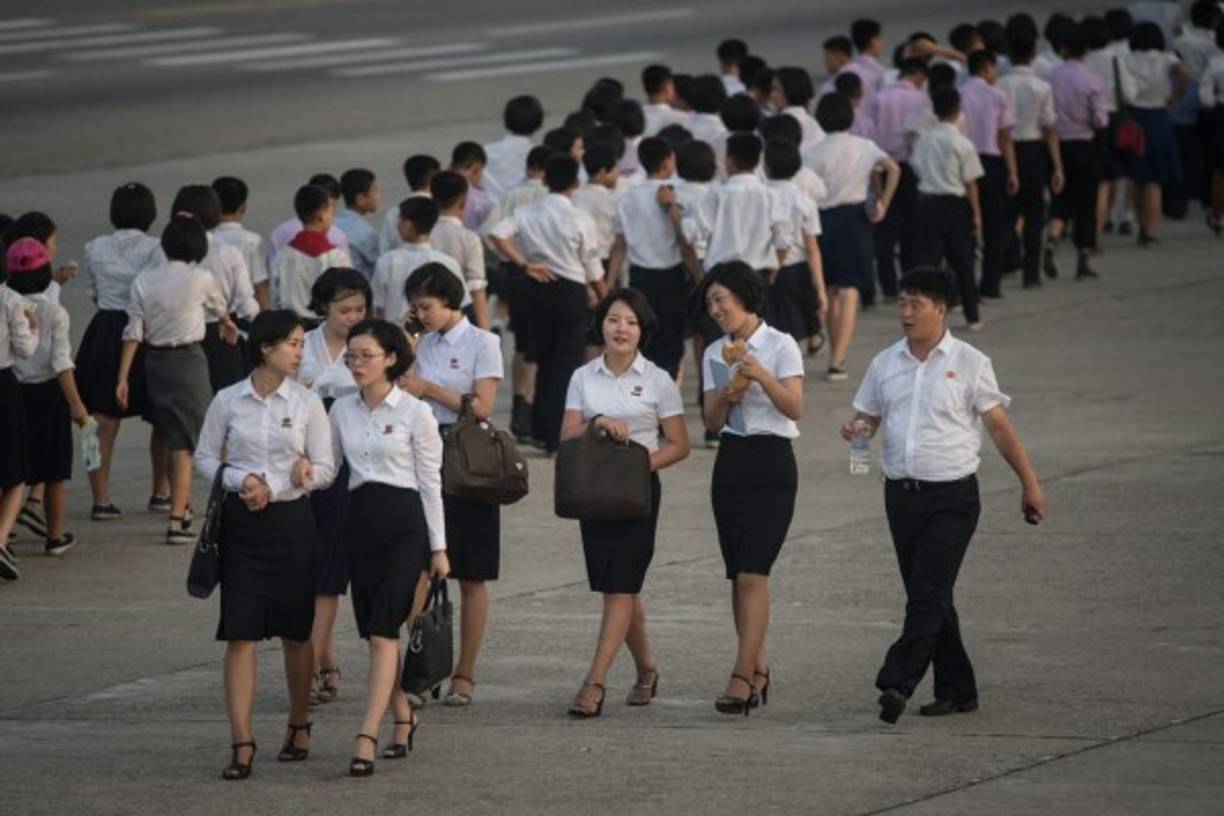 Jóvenes universitarios caminan tranquilamente por la capital tras el lanzamiento de un misil intercontinental el pasado 4 de Julio.