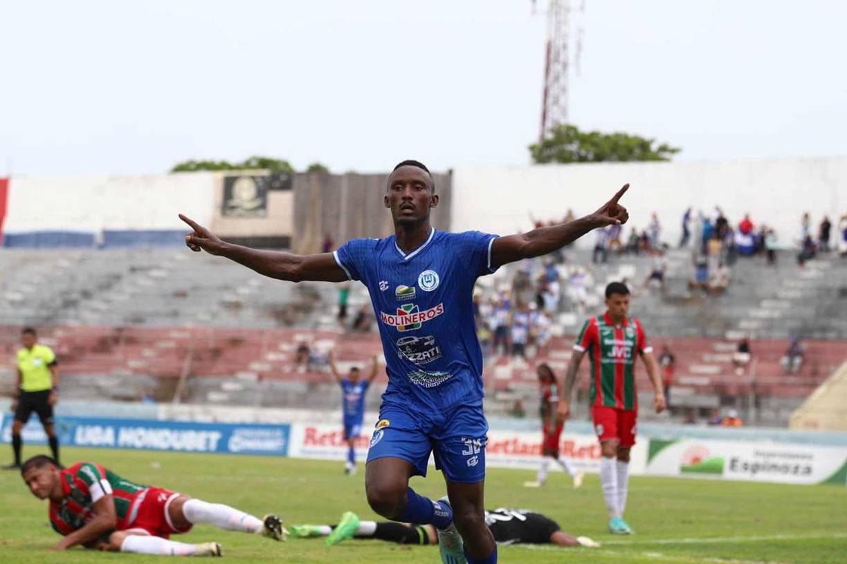 El panameño Aldair McKenzie celebrando su gol contra el Marathón. Javier Rivera y Luis Ortiz quedaron tendidos en el suelo.