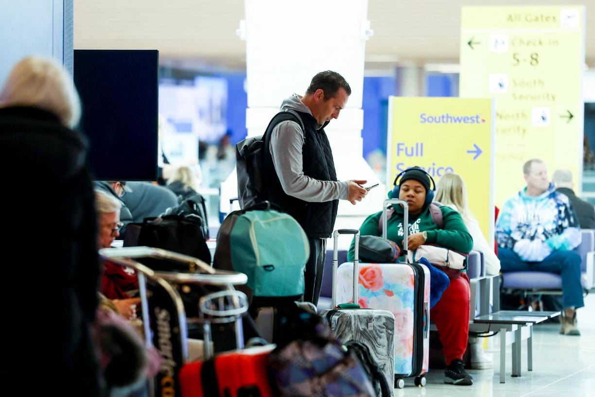 DENVER, CO - FEBRUARY 22: A traveler checks his phone during a winter storm at Denver International Airport on February 22, 2023 in Denver, Colorado. More than 1000 flights have been canceled across the U.S. as the storm impacts travel around the country. Michael Ciaglo/Getty Images/AFP (Photo by Michael Ciaglo / GETTY IMAGES NORTH AMERICA / Getty Images via AFP)