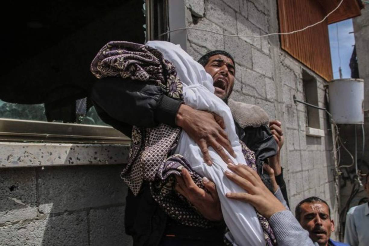 Un pariente palestino de la niña Seba Abu-Arrar, de catorce meses de edad, lleva su cuerpo durante su funeral en el vecindario de Al-Zaitun, al este de la ciudad de Gaza. EFE