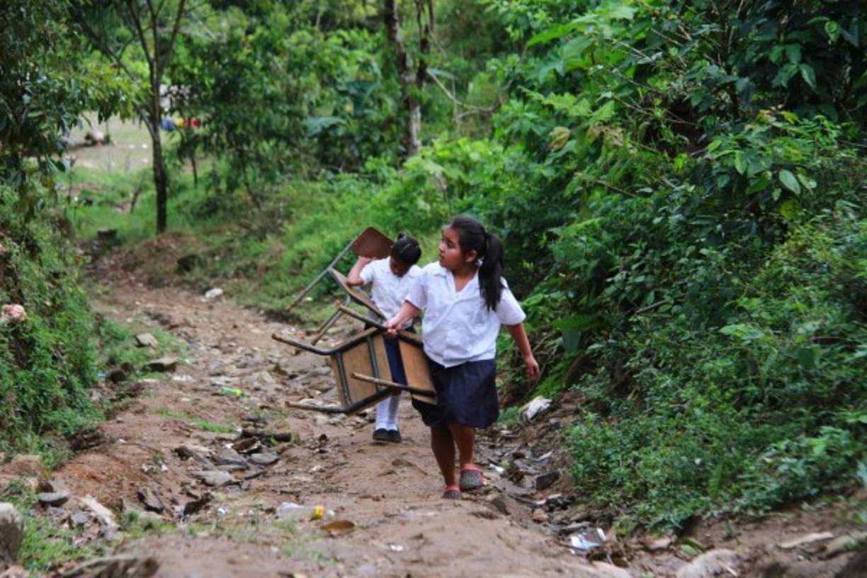 Dos niñas caminan para llegar a su escuela, en el Merendón, Honduras, donde muchos van a caminar por placer; los pequeños lo hacen por el pan del saber.<br/>