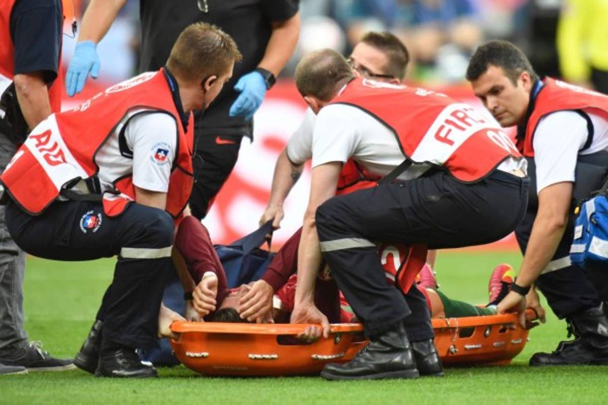 Portugal's forward Cristiano Ronaldo is carried off the pitch on a stretcher after being injured during the Euro 2016 final football match between Portugal and France at the Stade de France in Saint-Denis, north of Paris, on July 10, 2016. / AFP PHOTO / PHILIPPE DESMAZES