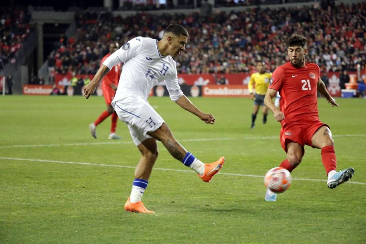 Kevin López mandando un centro al área de Canadá ante la marca de Jonathan Osorio.