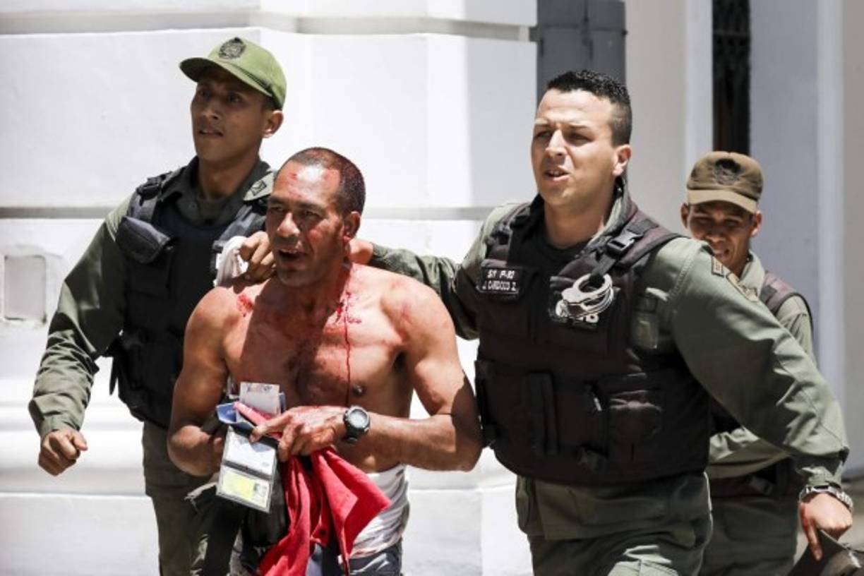 Cerca de un centenar de personas, algunas encapuchadas, con palos y tubos, y vestidas de rojo, entraron a los jardines del Palacio Legislativo y detonaron bombas de estruendo, desatando el caos.